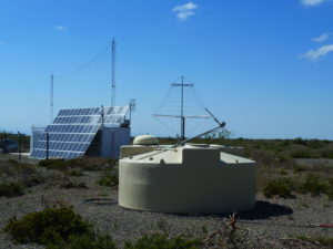 Water Cherenkov tank in front of an LPDA antenna and the central radio station.